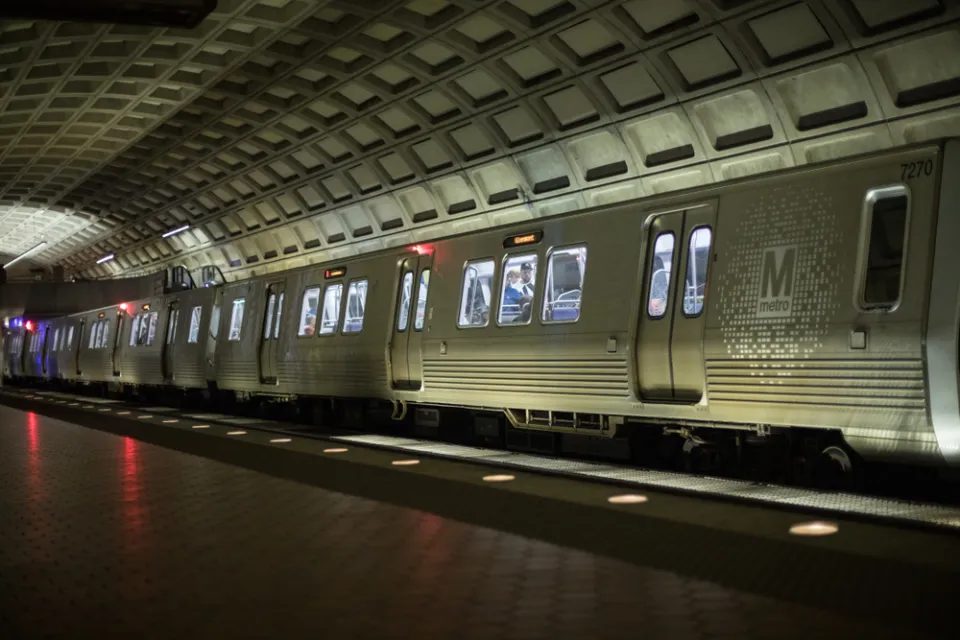 Silver DC Metro train in underground station with high arched ceiling